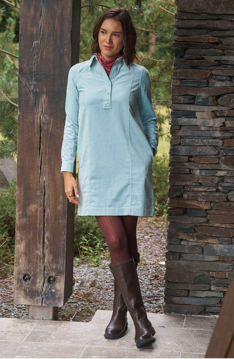 Femme portant une robe-chemise bleu clair et des bottes montant jusqu'aux genoux en plein air